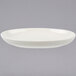 A Tuxton eggshell white china baker with a rim.