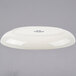 A white Tuxton shallow oval baker with a logo on it.