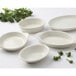 A group of Tuxton eggshell white bakers on a white surface with broccoli inside.