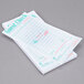 A stack of Royal Paper Mexican Themed White Guest Checks on a counter.
