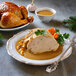 A plate of food with turkey, gravy, and a vegetable.