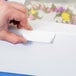 A hand points at a white bakery box with a window.