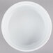 A CAC white china fluted souffle bowl on a gray surface.