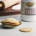 A plate of cookies next to a white container of Golden Barrel Supreme Baking Molasses with a yellow label.