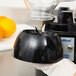 A person using a Waring blender to fill a black bowl with a clear pitcher.