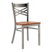 A Lancaster Table & Seating metal cross back chair with a wooden seat and back.