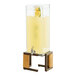 A Cal-Mil Sierra bronze and rustic pine beverage dispenser with a yellow liquid and lemon slices.