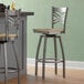 Two Lancaster Table & Seating metal and wood bar stools with wooden seats at a counter.