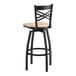A black metal swivel bar stool with a cross back design and a light driftwood seat.