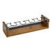 A Cal-Mil wooden and metal wine tasting flight rack with four wine glasses on it.