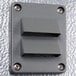 A grey rectangular Kolpak wall plate with metal corners and two holes.