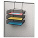 A black mesh Fellowes 3-tray organizer on a black surface with different colored papers in each tray.