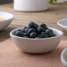 A white American Metalcraft melamine bowl with blueberries on a table.