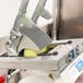 A close-up of a Vollrath Redco Onion Slicer slicing yellow onions.