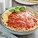A bowl of spaghetti with Napoli tomato sauce and basil.