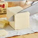 A knife cutting a block of Wuthrich unsalted European butter.
