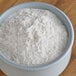 A bowl of King Arthur Flour on a wood surface.