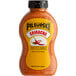 A Pilsudski Sriracha Mustard squeeze bottle with a yellow label.