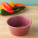 A pink HS Inc. polyethylene ramekin on a wood table.