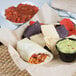 A plate of Father Sam's Bakery tortilla wraps with a bowl of salsa.