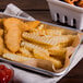 A tray of crinkle cut fries in a white basket with ketchup.