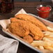 A tray of Tyson breaded chicken tenderloins and french fries.