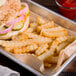 A tray of a sandwich, pickles, and Saint-Arneault crinkle cut French fries.