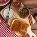 A piece of bread with Kime's pumpkin butter spread next to apples.