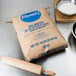 A bag of Pillsbury Balancer High Gluten Flour on a counter next to a wooden rolling pin.