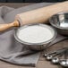 A silver bowl of Pillsbury High Gluten Flour with a rolling pin.