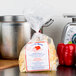 A package of Little Barn Homemade Wide Egg Noodles sits on a counter next to a silver pot and a red bell pepper.