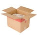 A cardboard box with a red label on the front and a plastic bag inside containing Tyson Red Label Homestyle Chicken Tenderloin Fritters.