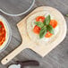 Caputo 00 pizza dough with tomatoes and basil on a wooden board.