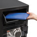 A hand opening a black FireKing Depository Security Safe.