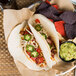 A plate of tacos with Mission tortillas and guacamole on the side.