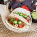 A plate of tacos with Mission tortillas and salsa and guacamole.