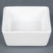 A CAC white square bowl on a gray surface.