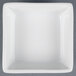 A CAC white square bowl on a gray surface.