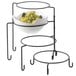 A Tablecraft 4 tier metal display stand with bowls of grapes and lemons.