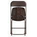 The back of a brown Lancaster Table & Seating folding chair with a black metal frame.