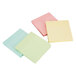 A close-up of several stacked Universal pastel square sticky notes in three different colors.