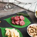 A plate of American Metalcraft Leaf Cheese Paper with cheese, olives, nuts, and meat on a table.