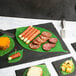 A plate of cheese and meat wrapped in leaf cheese paper on a table.