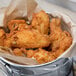 A metal container filled with Pierce Chicken Breaded Chicken Wing-Dings.