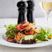 A plate of salad with Fresh Gourmet Tri-Color Tortilla Strips, vegetables, and cheese.