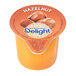 A close up of a container of International Delight Hazelnut Single Serve Non-Dairy Creamer.