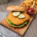A chicken sandwich with pickles and a side of fries.