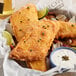 A basket of High Liner Budweiser Battered Alaska Pollock fillets with fried fish and chips and white sauce with capers.