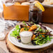 A plate of salad with Ken's Deluxe Bleu Cheese dressing on a table.