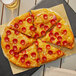 A pizza with Hormel pepperoni slices on a plate.